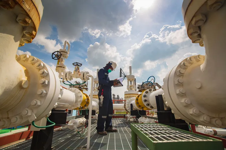 male-worker-inspection-at-steel-long-pipes-and-pipe-elbow-in-station-oil-factory-during-refinery-2068701212