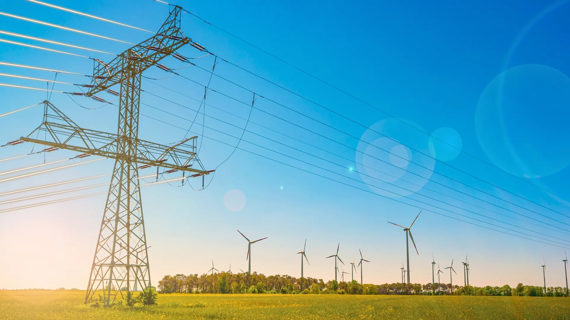 industrial-high-voltage-power-line-pylons-and-wind-turbines-2216804985